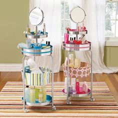 three tiered trays with cosmetics and personal care items on them in front of a window