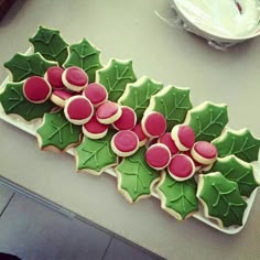 cookies decorated with holly leaves and pink frosting