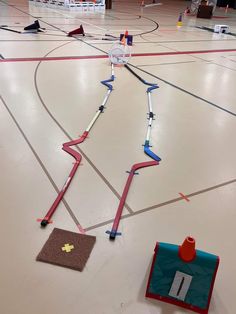 an indoor basketball court with several pieces of equipment on the floor and one piece of tape taped to it