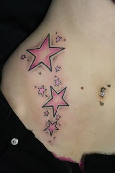 a woman's back with pink stars on her stomach and small diamond studs