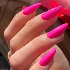 a woman's hand with bright pink nail polish