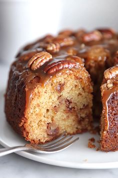 a bundt cake with pecans on top and a fork in the foreground