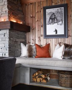 a room with wood paneling and pillows on a bench next to a fire place