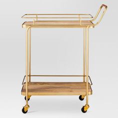 a gold metal and wood serving cart