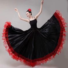 a woman in a black and red dress is dancing