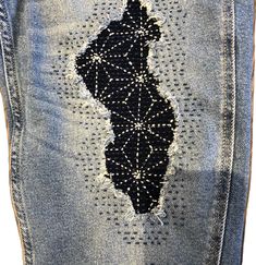 a pair of jeans with an embroidered map on it