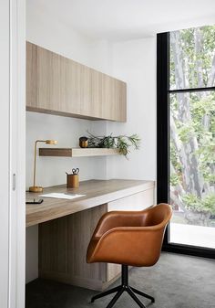 a chair sitting in front of a desk next to a window