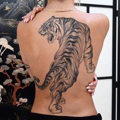 a woman with a tiger tattoo on her back