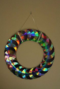 a colorful circular ornament hanging on a wall with a string attached to it