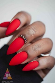 Go bold with these matte red almond-shaped nails, accented with a ring embellishment. Perfect for a striking and elegant fall style. Find more amazing nail ideas at NailHow.com and save this pin! Matte Red Nails Design, Red Matte Nails Design, Red Nail Designs Almond, Red Glam Nails, Matte Red Nails, Chiefs Jacket, Red Almond Nails, Elegant Almond Nails, Iconic Red Lipstick