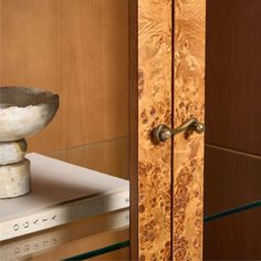 a vase sitting on top of a table next to a wooden cabinet