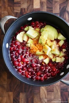 apples and cranberries are being cooked in a pot