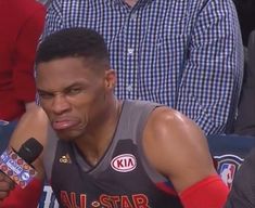 a basketball player sitting in the stands with a microphone