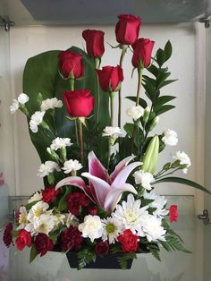 a vase filled with red and white flowers