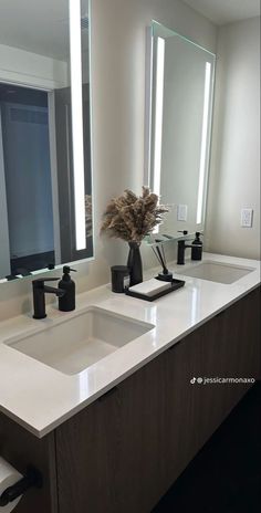 a bathroom with two sinks and mirrors in it