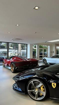 several luxury sports cars are parked in a showroom