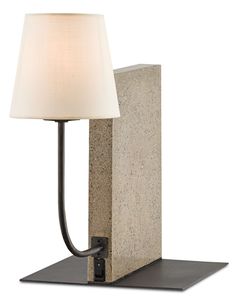 a lamp is plugged into a concrete block with a white shade on it's side