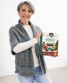 an older woman holding up a book in her hands