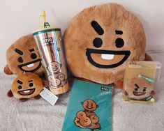 a stuffed animal and other items are on a bed next to a travel mug, coffee cup, and sticker