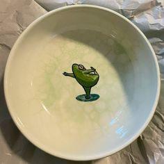 a white bowl with a green frog painted on it