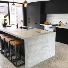 a kitchen with marble counter tops and black cabinets