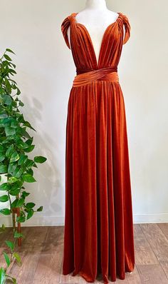 a dress on a mannequin next to a potted plant