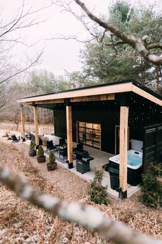 an outdoor hot tub in the middle of a wooded area with tables and chairs around it