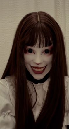 a woman with long brown hair wearing a creepy mask