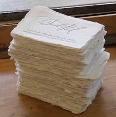 a stack of white paper sitting on top of a wooden table