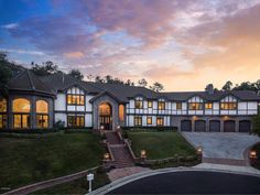 a large white house with lots of windows and lights on it's front porch