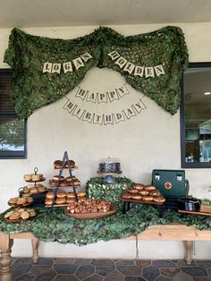 a table topped with lots of pastries on top of a stone floor next to a window