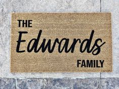 a door mat with the words the edwards family on it in front of a stone wall