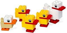 three lego ducks are shown in different colors and sizes, with one duck looking at the camera