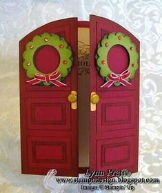 two red doors decorated with wreaths and bows on top of each door are shown