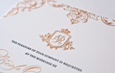 an ornate gold and white wedding card with the letter d on it