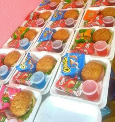 several trays filled with food sitting on top of a table next to each other