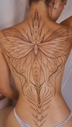 a woman's back with an intricate tattoo design on her body and the image of a butterfly