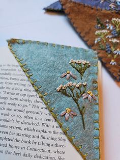 two triangle shaped bookmarks with flowers on them