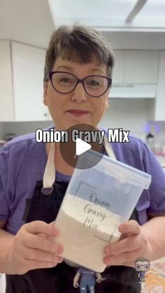 a woman in an apron holding up a bag of onion cravy mix with the words onion cravy mix on it