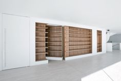 an empty room with wooden shelves and white walls