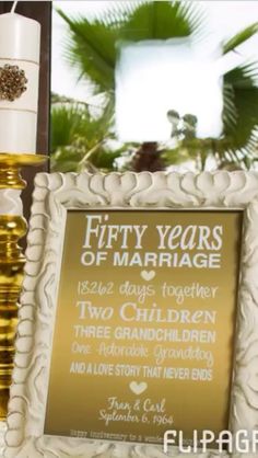 an anniversary gift for two children is displayed in front of a wedding sign and candle