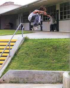 a man flying through the air while riding a skateboard in front of a building