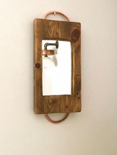 a mirror mounted to the side of a wall with an electrical cord in front of it