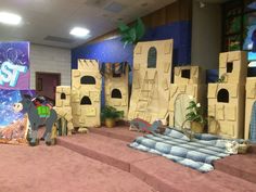 an indoor play area with cardboard castle and fake animals