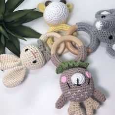 several crocheted toys are arranged next to a plant