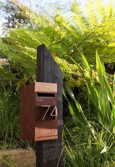 a wooden mailbox sitting in the grass