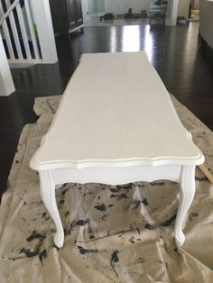 a white table sitting on top of a wooden floor