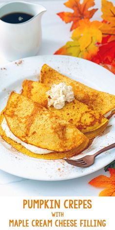 pumpkin crepes with maple cream cheese filling on a white plate next to a cup of coffee