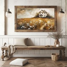 a painting hanging on the wall above a wooden bench in a room with white walls and wood flooring