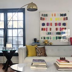 a living room filled with furniture and a painting on the wall above it's windows